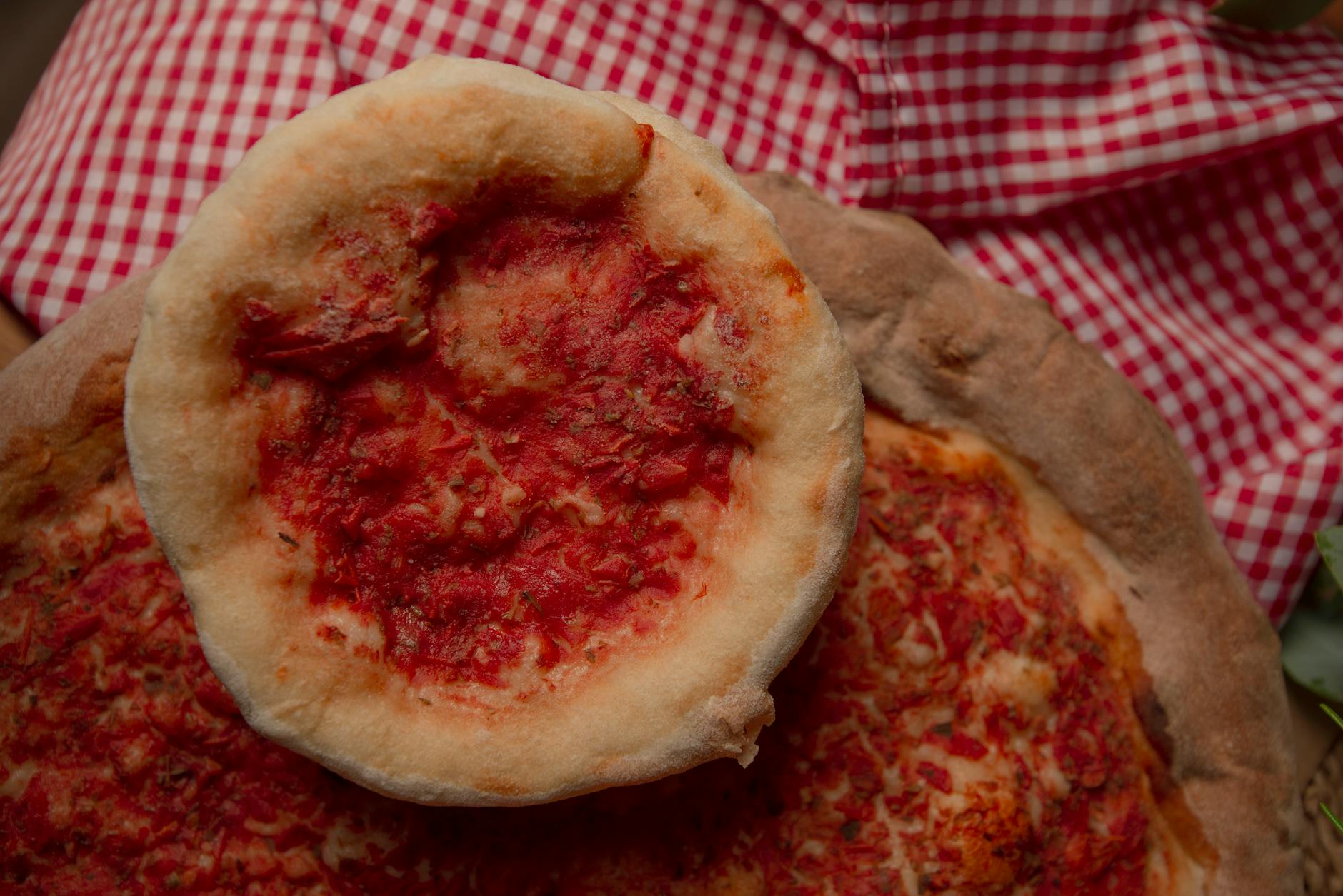 Domowe rustykalne mini pizze z sosem pomidorowym na kraciastym obrusie