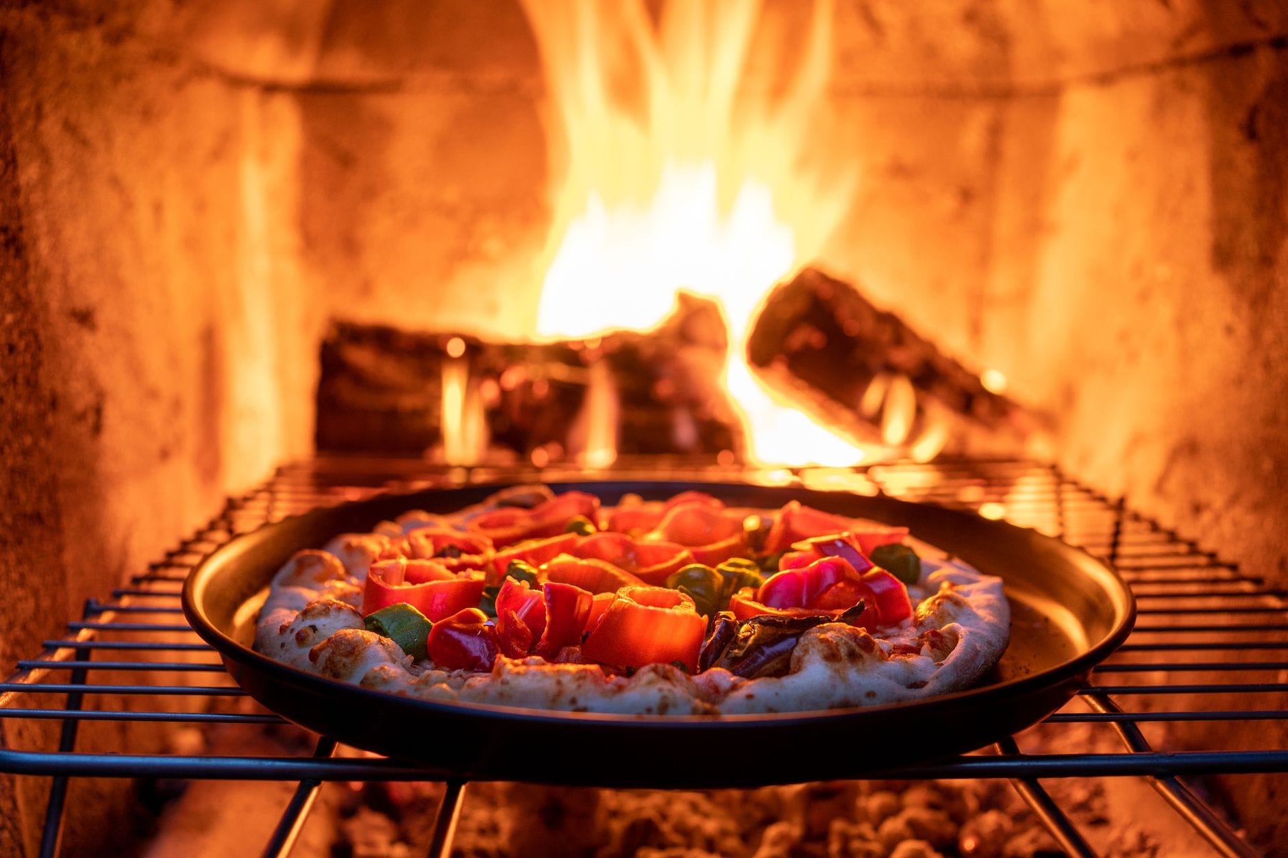 Pizza z kolorowymi dodatkami pieczona w piecu opalanym drewnem