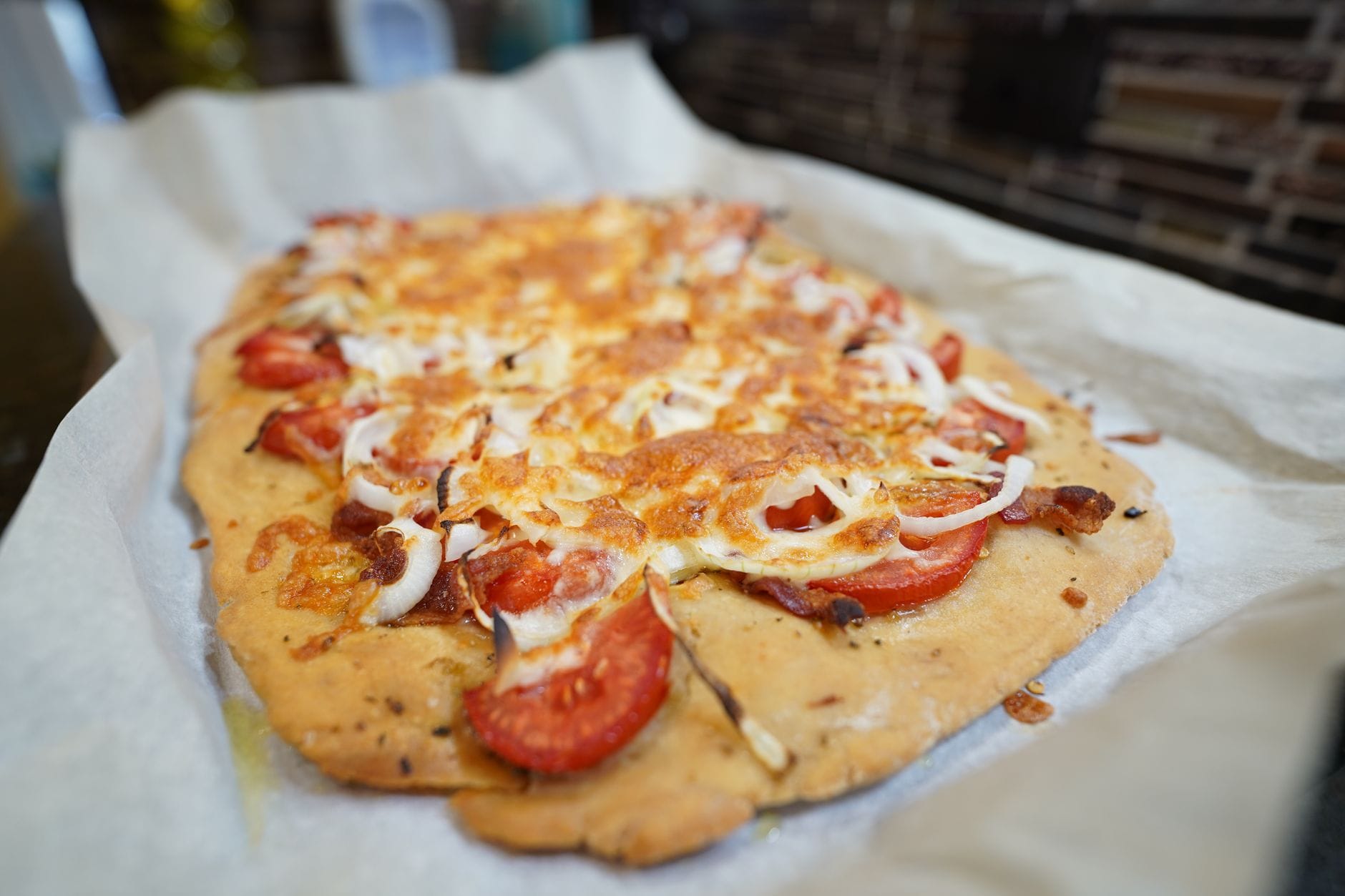 Pizza na papierze do pieczenia z serem, pomidorami i cebulą Pizza na papierze do pieczenia z serem, pomidorami i cebulą