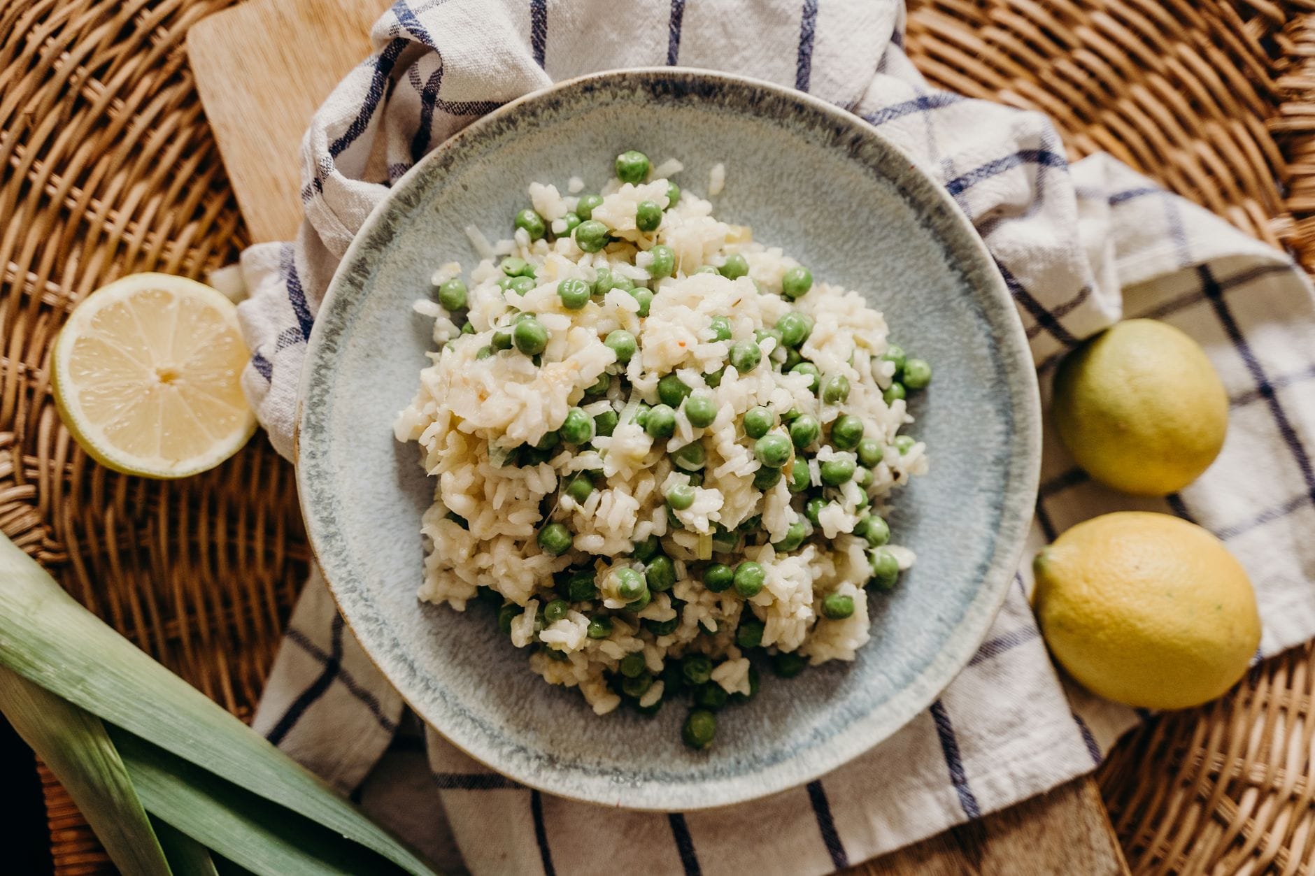 Kremowe risotto z groszkiem, szynką parmeńską i miętą dla fanów nieoczywistych połączeń Risotto z zielonym groszkiem i cytryną na wiklinowym tle